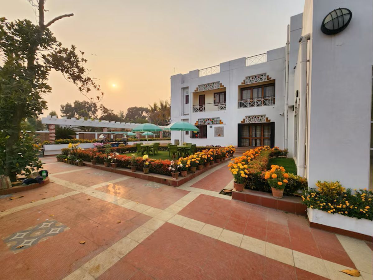 A courtyard with a tiled floor, potted plants, and outdoor seating.