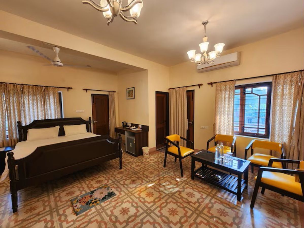 A hotel room with a bed, a desk, a chair, a table, and a window.