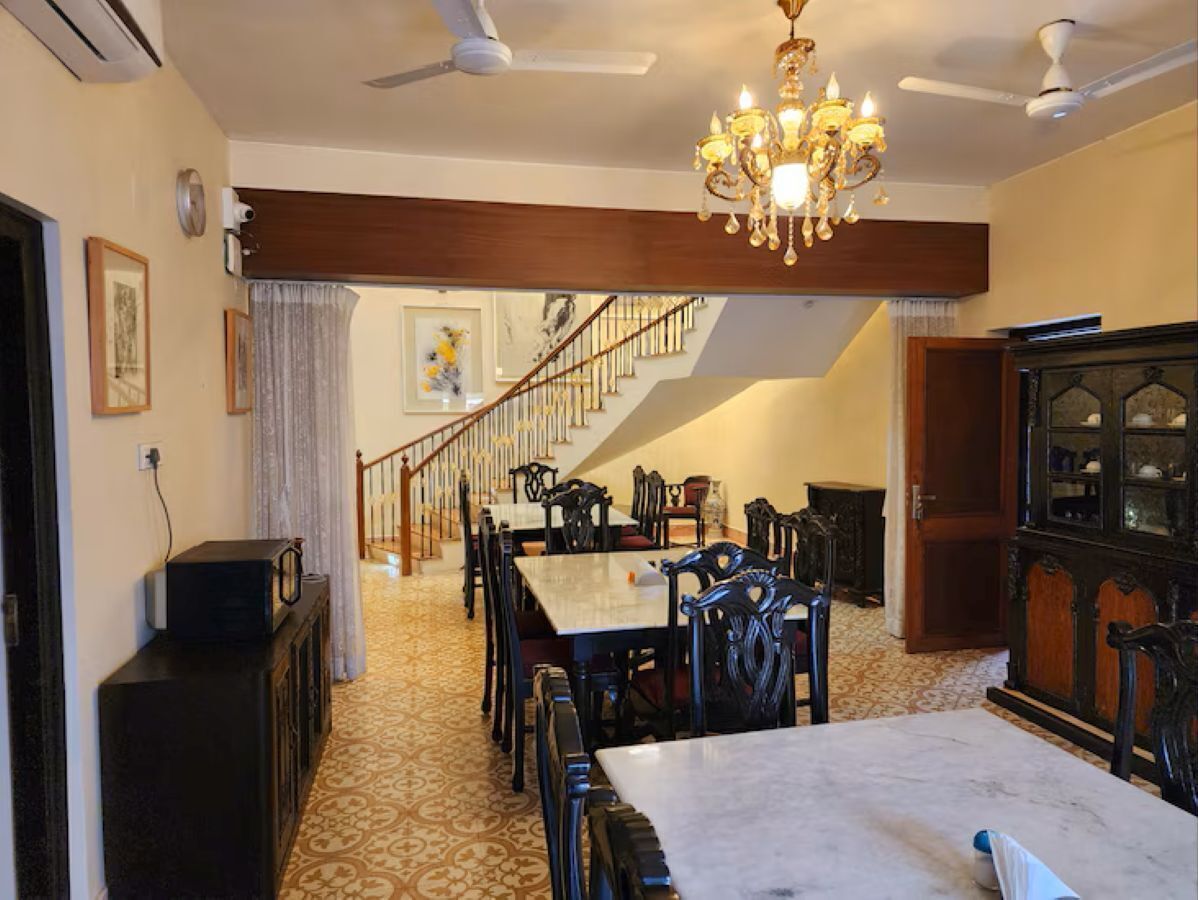 A dining area with a chandelier, a staircase, and a cabinet.