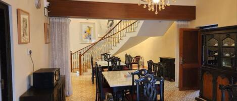 A dining area with a chandelier, a staircase, and a cabinet.