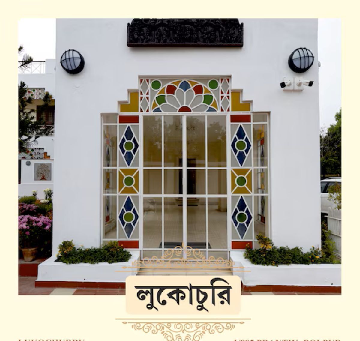 A building with a white facade, a decorative entrance with a glass door, and a sign with text.