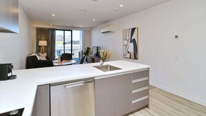Una cocina moderna con lavavajillas integrado, un fregadero y un comedor con mesa y sillas.