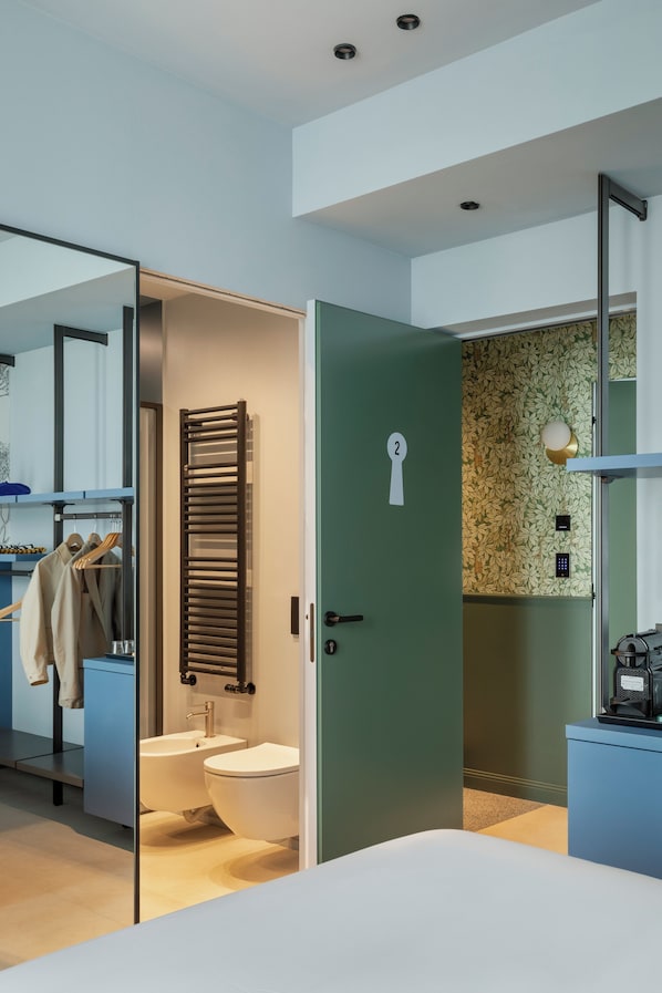 Une salle de bain moderne équipée de toilettes, d’un lavabo et d’un porte-serviettes.