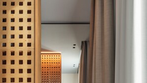 A room with a desk, chair, and a decorative partition with a grid pattern.