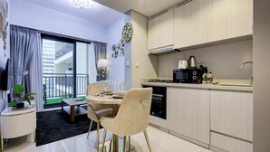 Eine moderne Küche mit Essbereich, ausgestattet mit einem Backofen, einer Kaffeemaschine und einem Spülbecken.