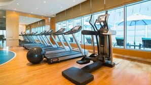 Ein Fitnessraum mit Laufbändern, einem Ergometer und einem Rudergerät.
