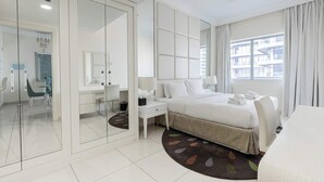 Ein modernes Hotelzimmer mit einem großen Bett, einem Schreibtisch, einem Stuhl und Blick auf die Stadt.