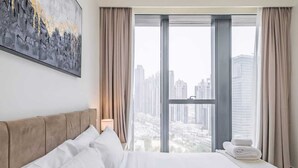 Una camera d'albergo con un letto grande, vista sulla città e un quadro appeso al muro.