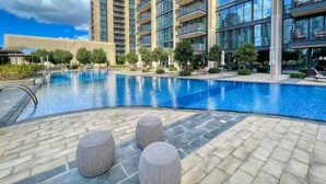 Una piscina con sdraio e un edificio moderno sullo sfondo.