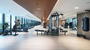 Ett modernt gym med löpband, styrketräningsmaskiner och en boxningssäck.