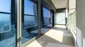 Un interior moderno con amplios ventanales, piso de baldosas limpias y vista a una obra en construcción.