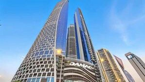 Un edificio moderno con fachada curva y el nombre 'DAMAC' bien visible.