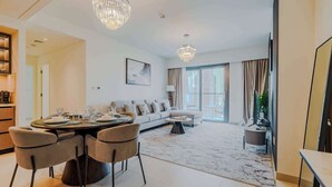 Ein modernes Wohnzimmer mit Essbereich, einer Sofagarnitur und einem Kronleuchter.