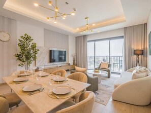Un salon moderne avec un coin repas, de grandes fenêtres et un balcon.