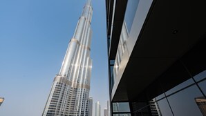 A modern skyscraper with a sleek, reflective glass facade. - Full Burj Khalifa View, Premium 3BR Furnished Unit (Dubai)