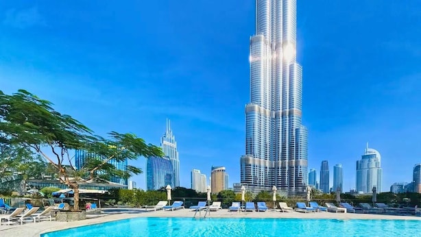 A pool area with lounge chairs and a view of the Burj Khalifa and surrounding high-rise buildings. - Full Burj Khalifa View, Premium 3BR Furnished Unit (Dubai)