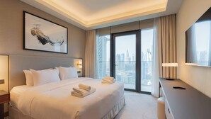 A hotel room with a large bed, a desk, and a view of a cityscape through a large window. - Full Burj Khalifa View, Premium 3BR Furnished Unit (Dubai)