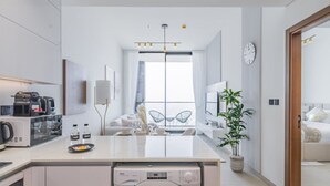 Una cocina moderna con lavadora y secadora integradas, un comedor con vistas y una sala de estar con un ventanal grande.