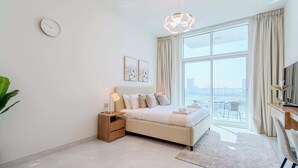 Een moderne slaapkamer met een groot raam, een bed, een nachtkastje, een lamp en een klok aan de muur.