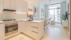 Una cocina moderna con una isla central, horno integrado y extractor de acero inoxidable.