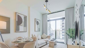 Una sala de estar moderna con comedor, un sofá, una silla colgante y un ventanal con vistas a la ciudad.
