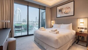 A hotel room with a large bed, a desk, and a view of the city skyline. - Full Burj Khalifa View, Luxury 3BR Unit, Downtown (Dubai)