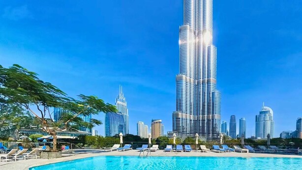 A pool area with lounge chairs and a view of the Burj Khalifa and surrounding high-rise buildings. - Full Burj Khalifa View, Luxury 3BR Unit, Downtown (Dubai)