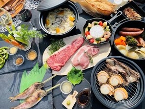 A variety of foods including grilled fish, meats, and vegetables, suggesting a dining setup.