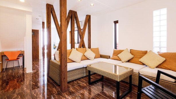 Una sala de estar moderna con un conjunto de sofá, una mesa de centro y una silla de mimbre.
