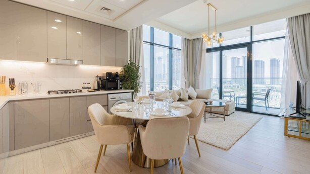 A modern kitchen with a dining area, large windows, and a city view. - Luxury 2BR Getaway - Prime Location in Meydan (Dubai)