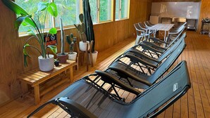 A room with wooden floors, a long table, several chairs, and potted plants. - Green Hotel Ibusuki (Misato)