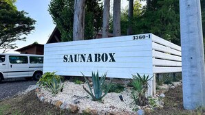 A sign for 'SAUNABOX' with a number '3360-1' and a white van parked nearby. - Green Hotel Ibusuki (Misato)