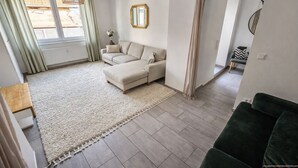 Un salon comprenant un canapé, une table basse, un tapis et donnant sur l’extérieur.