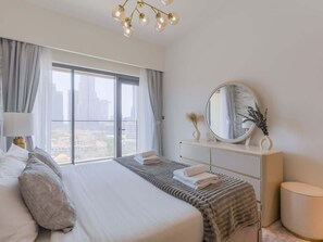 A modern hotel room with a large bed, a bedside table, a mirror, and a view of the city through large windows. - Full Burj Khalifa View, Luxury Furnished-Downtown (Dubai)