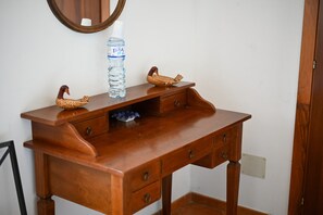 A wooden vanity with a mirror, a bottle of water, and two decorative swans. - Le Torrette Etrusche Room 6 – Comfort and Relaxation in Capalbio (Capalbio)