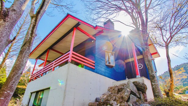 Un edificio moderno con balcón, una ventana con vistas y una base de piedra.