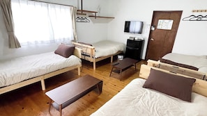 A compact room with two single beds, a small desk, a TV, and a wooden bench. - Marine Amkusa 2gokyo (Takaharu)