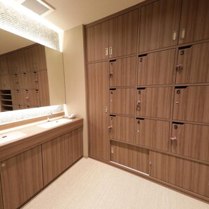 Ein Hotelbad mit Holfachschränken, einem Waschbecken und einem Spiegel.