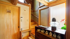 Un interior de madera con una escalera, un armario de madera con adornos y un farol.