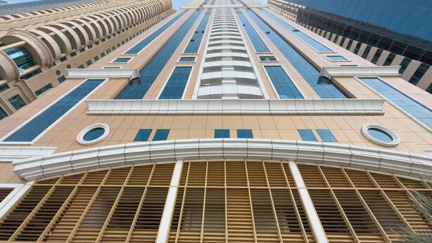 Ein Hochhaus mit moderner Architektur, ausgestattet mit mehreren Balkonen und großen Fenstern.