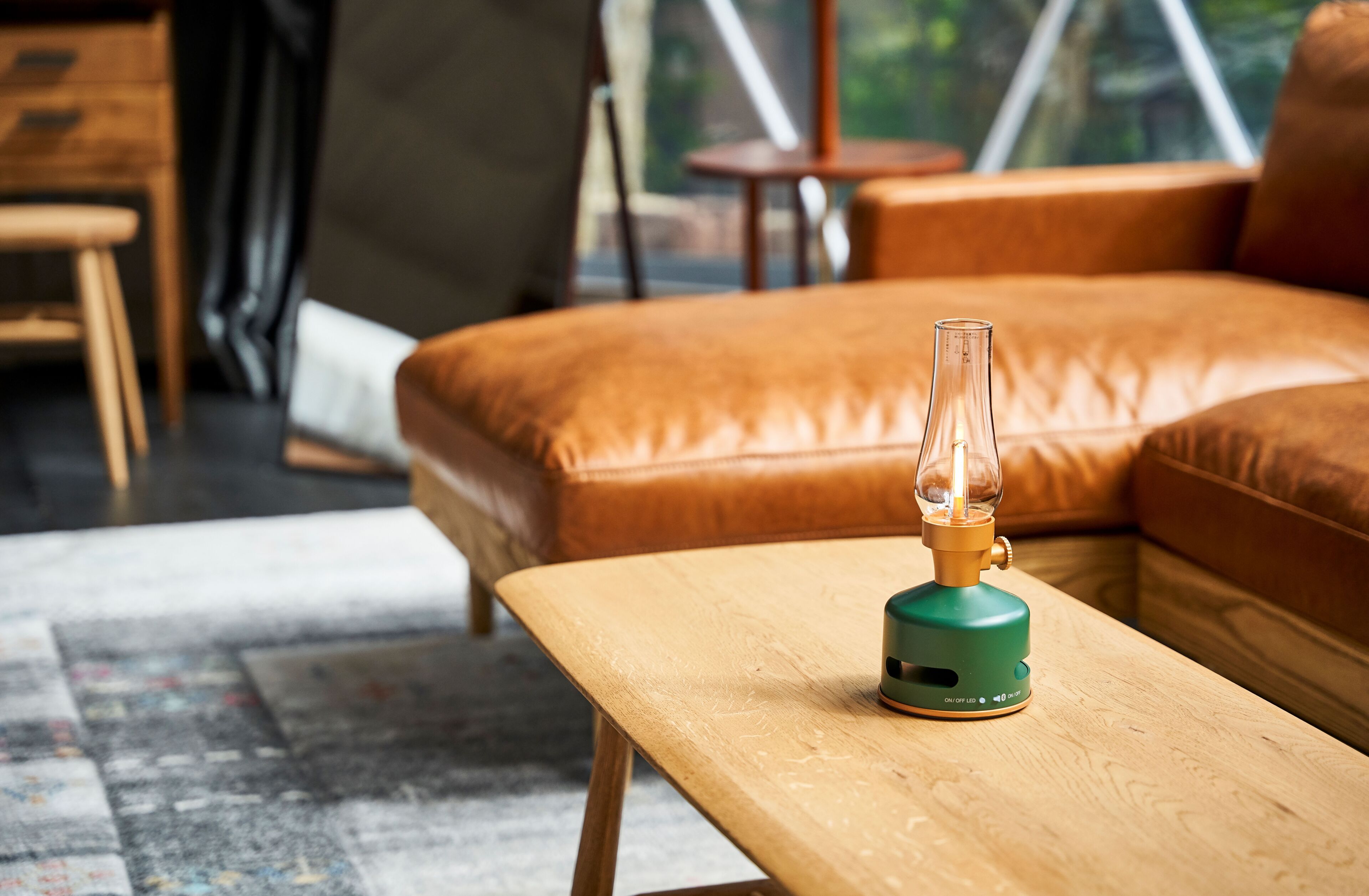 Ein modernes Wohnzimmer mit einer Couch, einem Holztisch und einer grünen Lampe.