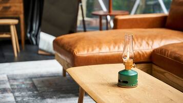 Ein modernes Wohnzimmer mit einer Couch, einem Holztisch und einer grünen Lampe.