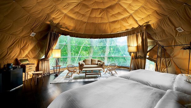 Una habitación con carpa, una cama, un sofá, un escritorio y una silla.