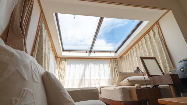 A bedroom with a skylight, a bed, a desk, and a chair. - Cottage Soulmate (Ishigaki)