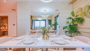 Een eetruimte met een witte tafel gedekt voor vier personen, omringd door fauteuils.