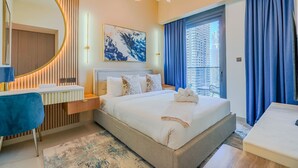 Een moderne hotelkamer met een groot bed, een bureau, een spiegel en uitzicht over de stad.