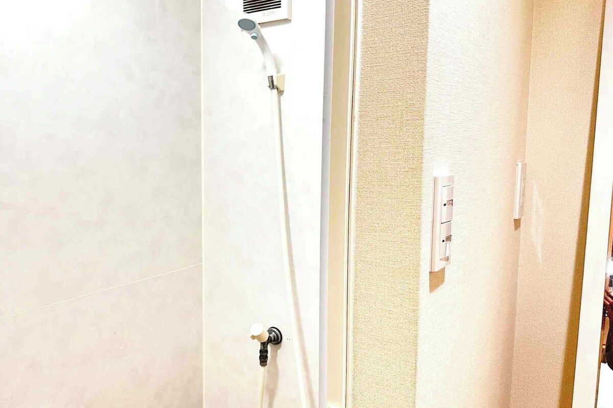 Ein Badezimmer mit Dusche, Handtuchhalter und Steckdose.