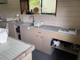 Una cocina moderna con un lavamanos doble, una estufa y una encimera con diversos utensilios de cocina.