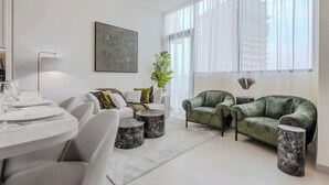 Un salon moderne avec un coin repas, comprenant un ensemble de canapés, une table basse et une table à manger avec des chaises.