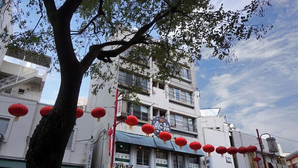 A traditional building with multiple floors, red lanterns hanging outside, and signage in a foreign language. - Yokohama Classic Apartment (Yokohama)